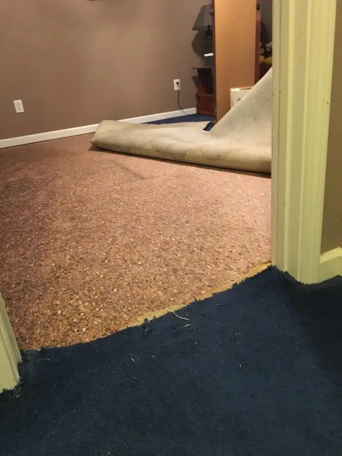 Carpet pad removal revealing water damage during Water Mitigation Services in Savage